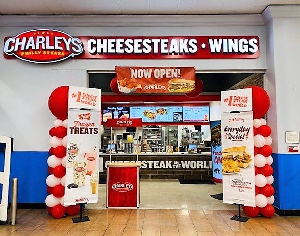 The entrance of Charleys Cheesesteaks and Wings at Highway 6, surrounded by balloons and signs.
